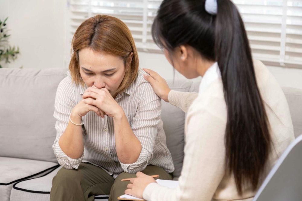 Therapist reassuring young woman in Santa Rosa addiction treatment.